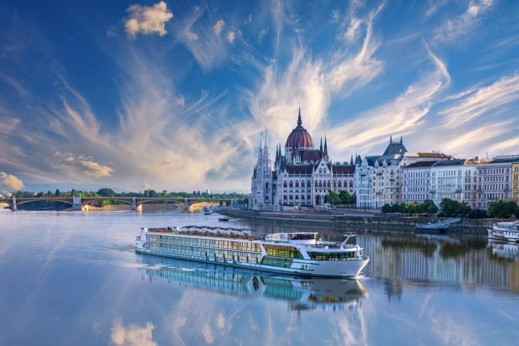 Budapest skyline with Parliament and river cruise boat.