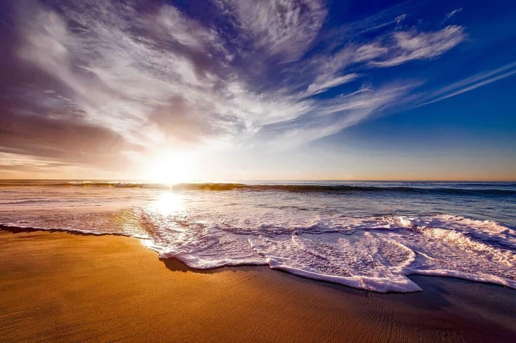 Beautiful sunset at a Minnesota beach with vibrant sky and gentle waves.