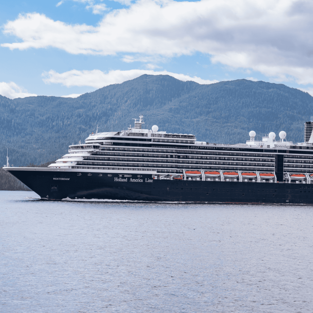 Cruise ship sailing in Alaska with mountains in background.