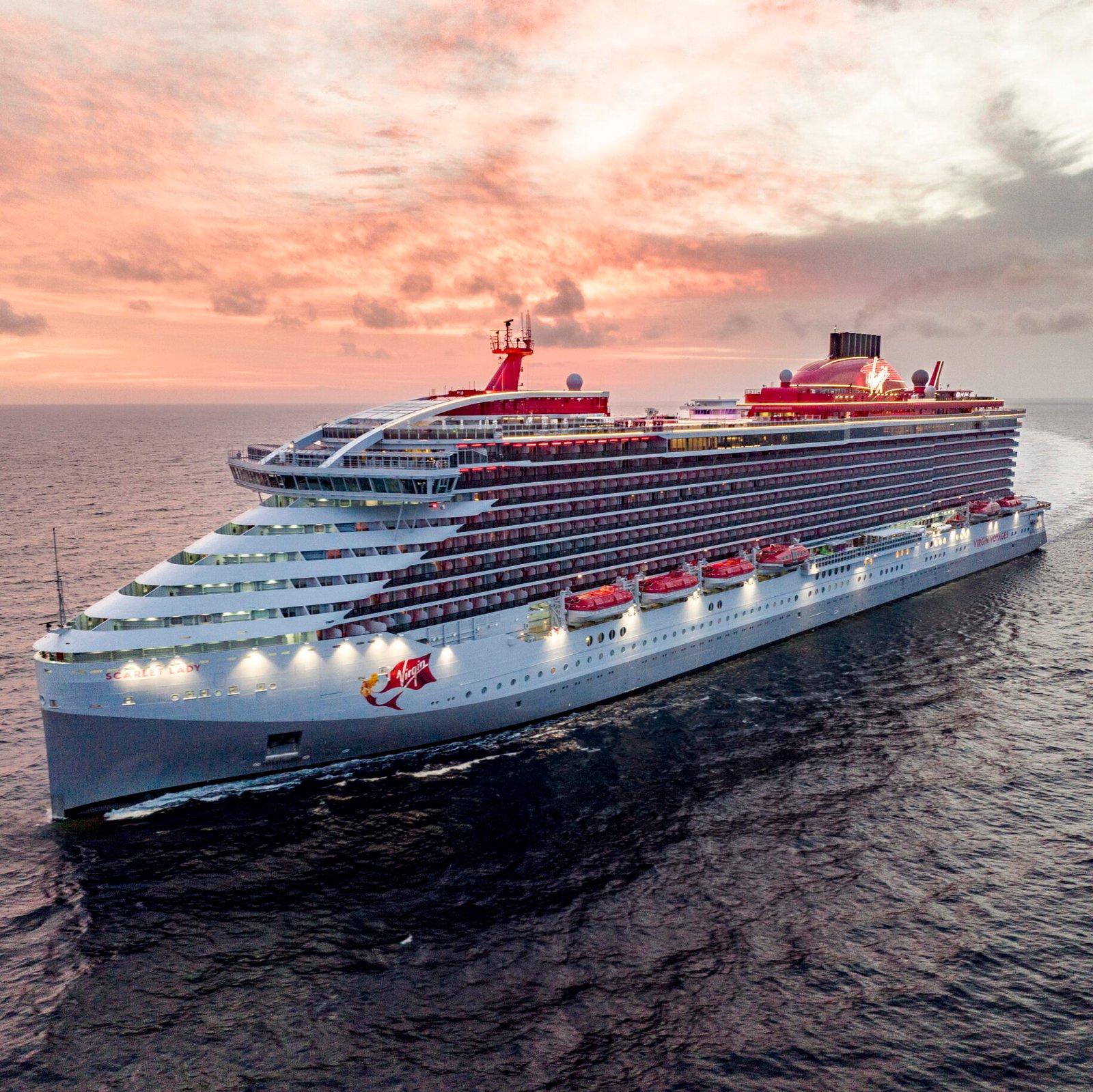 Luxury cruise ship sailing at sunset in the ocean.