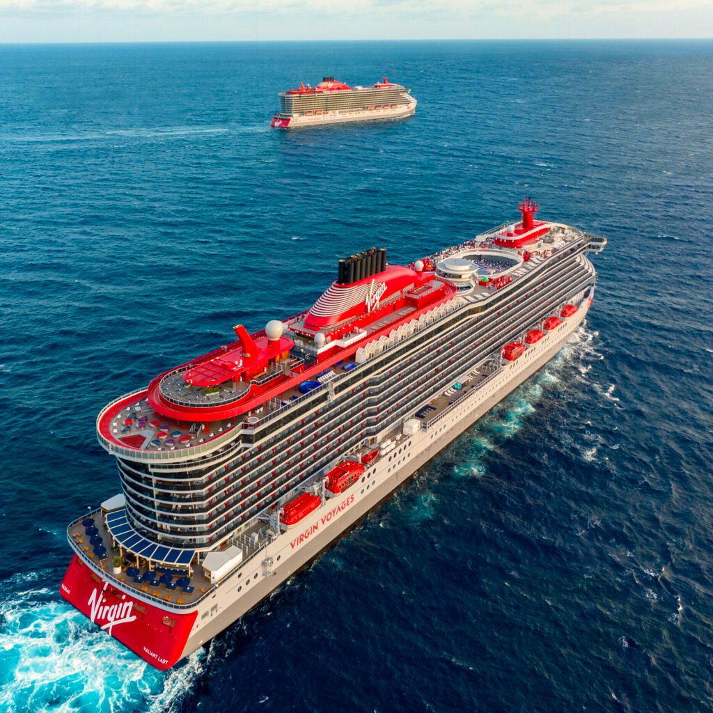 Large cruise ship sailing in the Caribbean Sea with a smaller vessel nearby.
