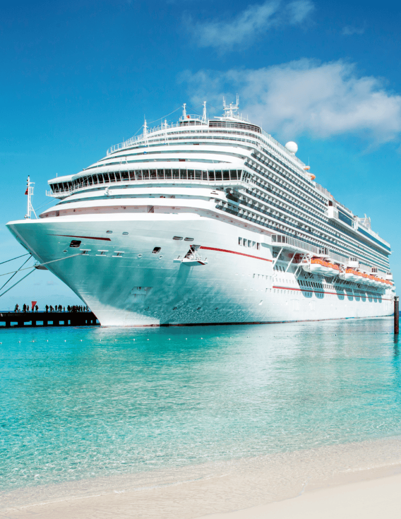 Large luxury cruise ship docked at the port under a blue sky.