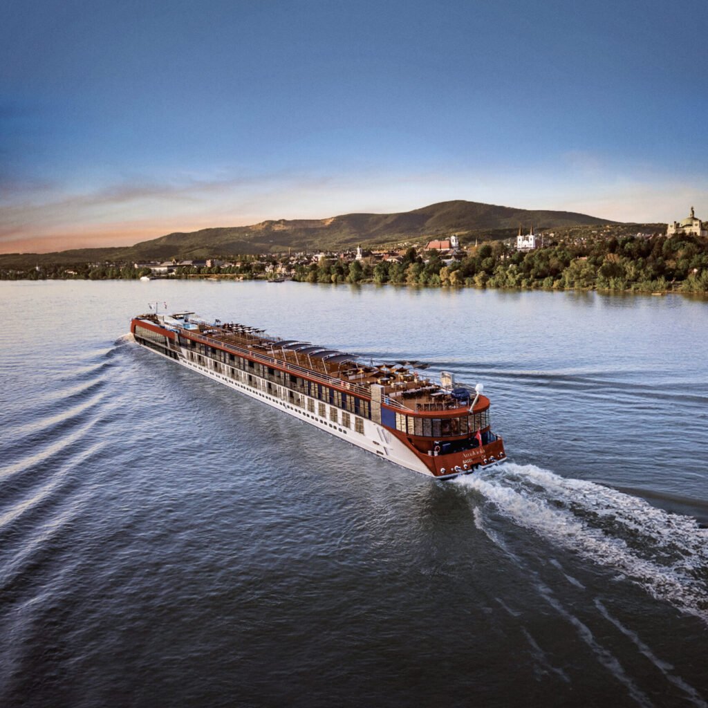 Passenger boat cruising on the Mississippi River at sunset.