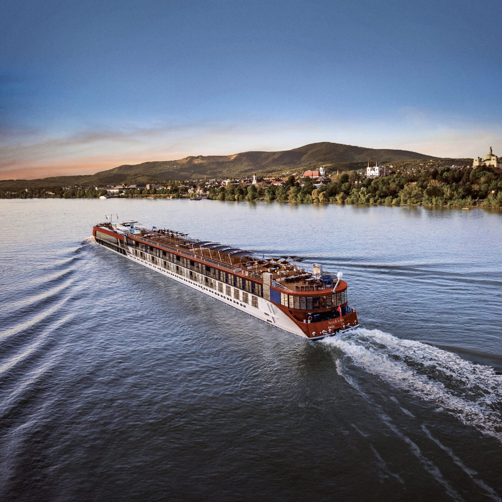 Passenger boat cruising on the Mississippi River at sunset.